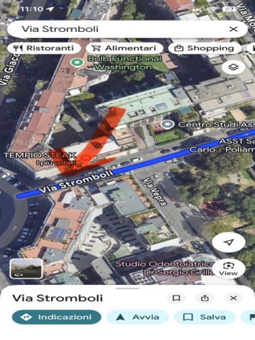 Buca vicino a tombino su marciapiede