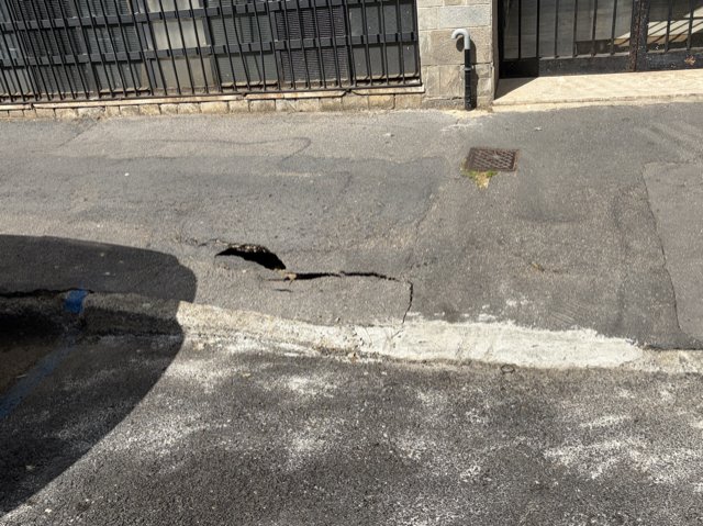 Marciapiede con buca e collassato